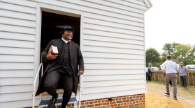 Joe Feaster, a part-time historical interpreter who portrays pastor Gowan Pamphlet, steps out of the reconstructed African Baptist Meeting House, now known as First Baptist Church of Williamsburg, during a rededication ceremony in Williamsburg, Va., Friday, Oct. 9, 2026.