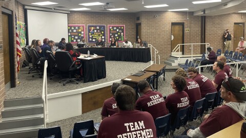 School board meeting July 13, members of Elite Community Outreach sit in the audience.