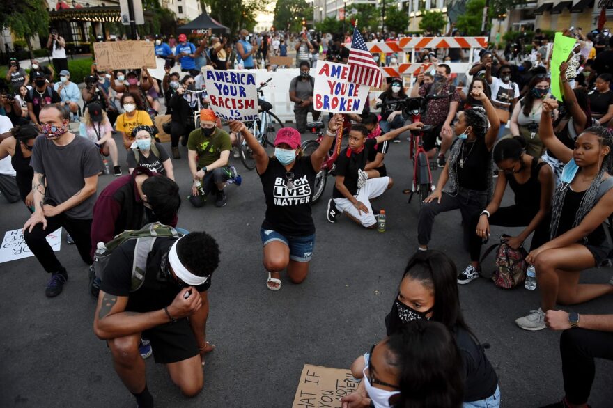 Demonstrators kneel as they protest against police brutality and the death of George Floyd, across from the White House on June 7.
