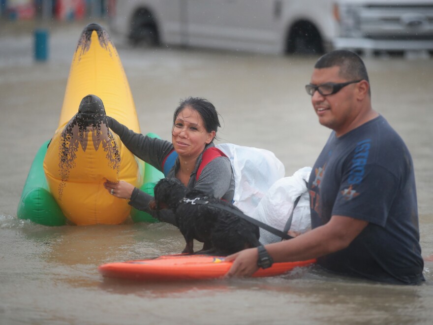 People make their way out of a flooded neighborhood in Houston on Monday. Many people are turning to social media for help.