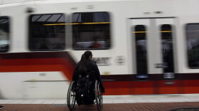 A rider waits to board an incoming MAX train in Portland, Ore. (Don Ryan/AP)