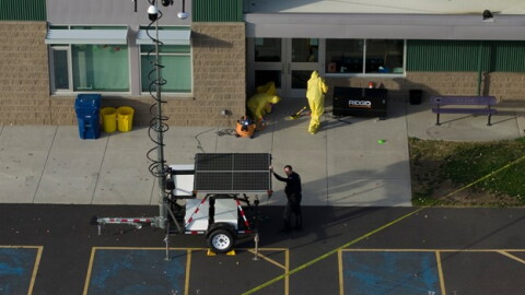 Hazardous materials workers clean up broken glass on the scene at Silver Rail Elementary School.