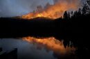 A large fire burns over a mountain during the night