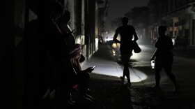 Residents walk on a street during a general blackout in Havana, Cuba, Friday, March 14, 2025. (AP Photo/Ramon Espinosa)