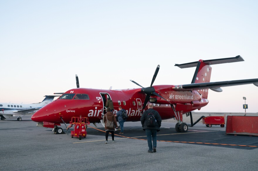 People board a plane at the airport in Nuuk.