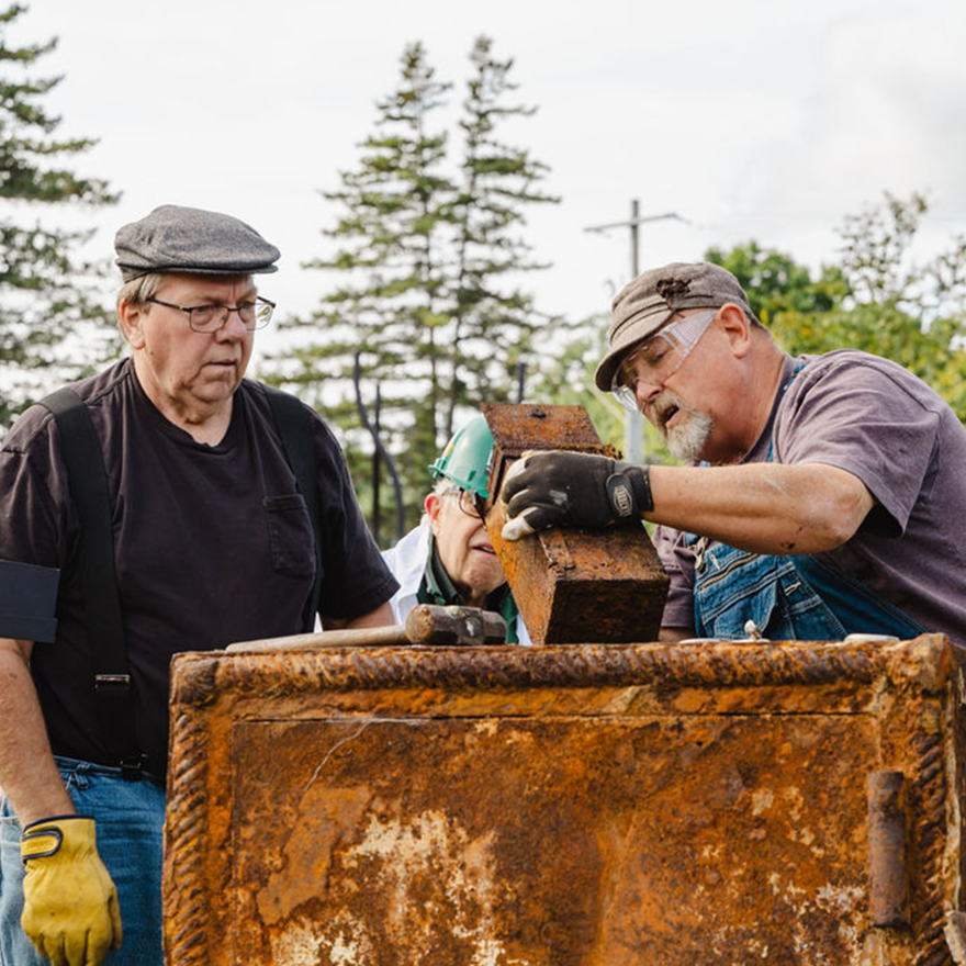 Designated safe-crackers peer into the metal box they found inside the century-old safe in Harrisville, Michigan on Sept. 20, 2026.