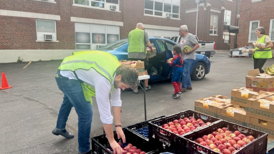 Volunteers load produce into waiting cars at Redemptorist’s weekly drive-thru distribution event.