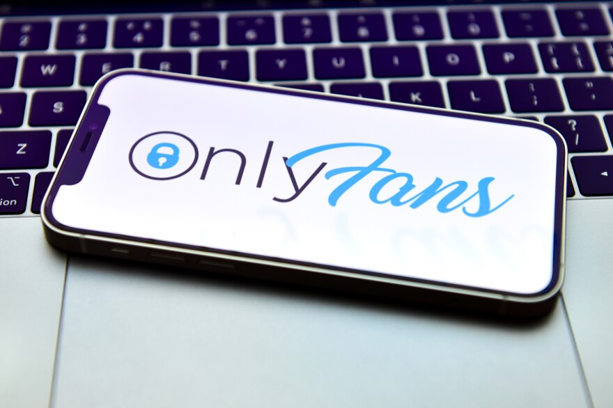 In this photo illustration, an OnlyFans logo is displayed on a smartphone. OnlyFans says it will continue allowing adult content on its website.