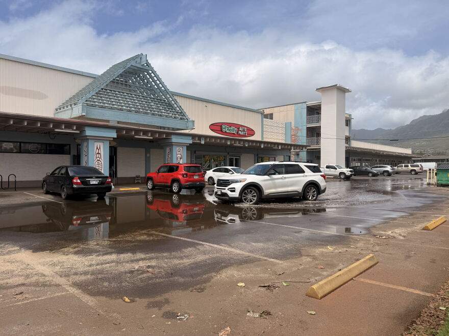 Sand and flooding from Hurricane Lowell at an O'Reilly Auto Parts parking lot on Farrington Highway on Oʻahu.