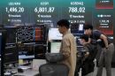 Currency traders work near a screen showing the Korea Composite Stock Price Index (KOSPI) and the foreign exchange rate between U.S. dollar and South Korean won at the foreign exchange dealing room of the Hana Bank headquarters in Seoul, South Korea, Tuesday, July 14, 2026. (AP Photo/Ahn Young-joon)