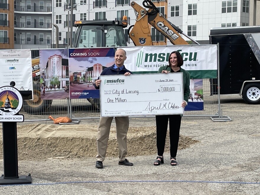 Mayor Andy Schor and MSUFCU President and CEO April Clobes hold a promotional check for a $1 million investment in the project.