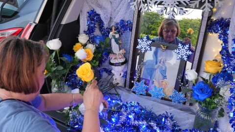 Egda Lee sets up an altar centered around a picture of the Virgin Mary which she carried with her when she crossed the U.S. border in 1984 pregnant with her son Neri Flores, as Nicaraguan parishioners of St. John Bosco Catholic Church celebrate the Dec. 8 feast of the Immaculate Conception, Sunday, Dec. 7, 2025, in Miami. (AP Photo/Rebecca Blackwell)