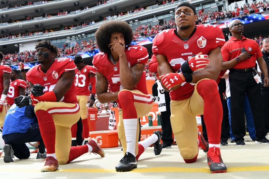 Former San Francisco 49ers quarterback Colin Kaepernick (middle) knelt on the sidelines during the national anthem to protest what he saw as the oppression of African-Americans in the United States.