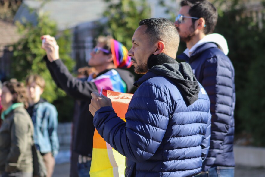 Attendees hold a Pride flag in honor of the five people shot and killed at Club Q. 