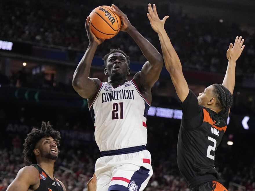 Connecticut forward Adama Sanogo scores past Miami guard Isaiah Wong during the second half of a Final Four college basketball game in the NCAA Tournament on Saturday, April 1, 2023, in Houston.