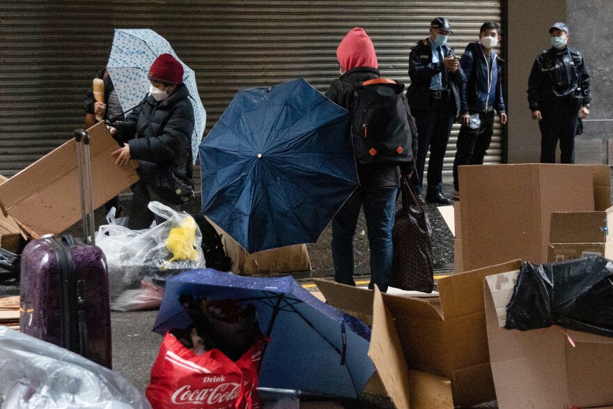 This Feb. 20 photo shows police officers watching as foreign domestic workers in Hong Kong seek shelter from cold weather.