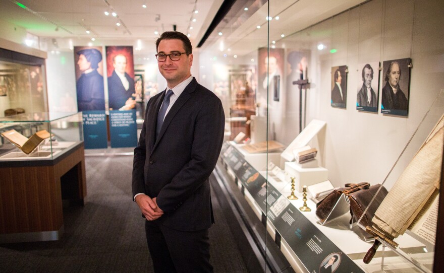 Religion curator Peter Manseau stands in the National Museum of American History's new exhibit, <em>Religion in Early America</em>.