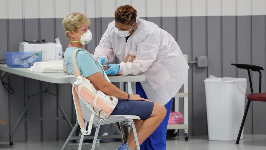 Person getting tested for COVID-19, a health professional injecting into the person's arm