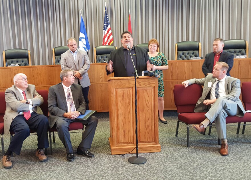 Jorge Perez addresses a crowded city council chambers in Fulton, Mo., after being introduced as the new owner of the town's hospital.