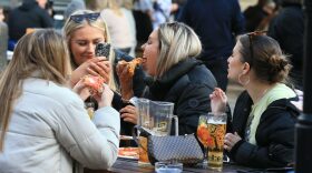 A group of friends eat pizza at a table outside the Water Lane Boathouse bar in Leeds, northern England, as coronavirus restrictions are eased across the country.