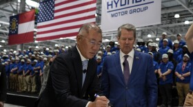FILE - Euisun Chung, Executive Chair, Hyundai Motor Company, left, stands with Georgia Gov. Brian Kemp as Chung signs an IONIQ 9 EV vehicle during a media tour and grand opening at the Hyundai Motor Group Metaplant America, March 26, 2025, in Ellabell, Ga. (AP Photo/Mike Stewart)