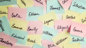 Post-It notes in yellow, pink, mint green with different popular baby names handwritten on them