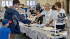 A voter collects his ballot at the election check-in desk at the Saltonstall School in Salem. (Robin Lubbock/WBUR)