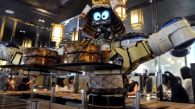Are robot waiters in our future in the U.S.? Here, a robot holds a tray of food at a restaurant in Bangkok.