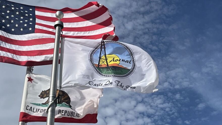 Three flags are displayed outside Avenal government offices.