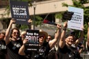 People carrying signs opposed to a ban on transgender people serving in the U.S. military participate in the Washington Pride parade, Saturday, June 20, 2026, in Washington.