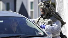A medical personnel member takes samples of person at a "drive-thru" coronavirus testing lab set up at Somerville Hospital in Somerville, Massachusetts. (Joseph Prezioso/AFP via Getty Images)