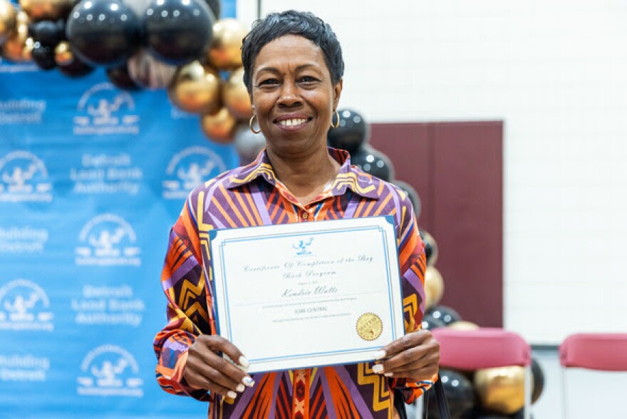 Kendric Watts holds the deed to her home in Detroit.