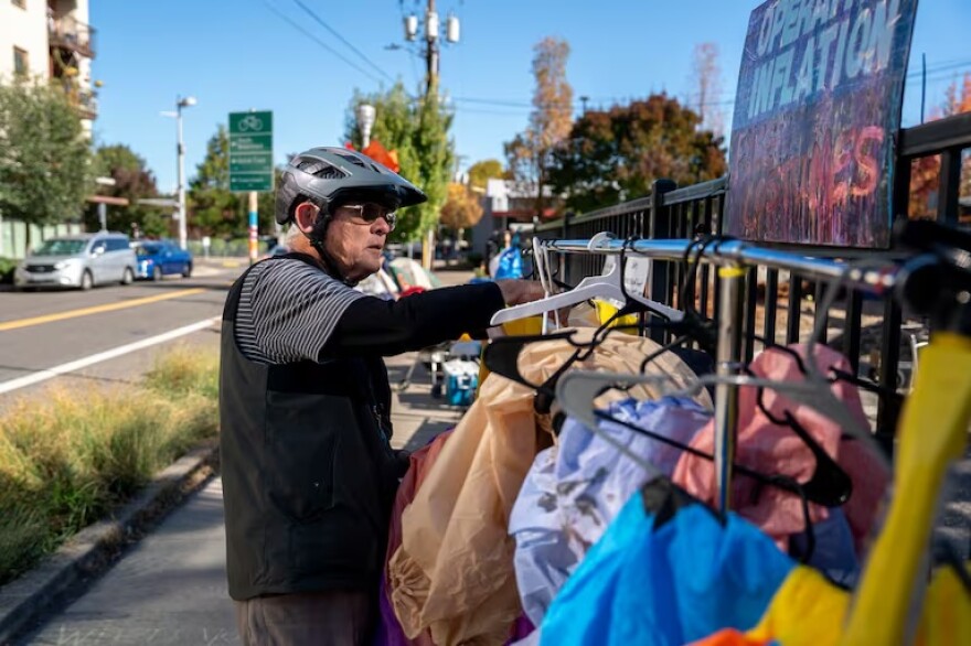 Fred looks through the costume rack, nicknamed "Operation Inflation", outside the U.S. Immigration and Customs Enforcement facility in Portland, Ore., on Wednesday, Oct. 15, 2025.