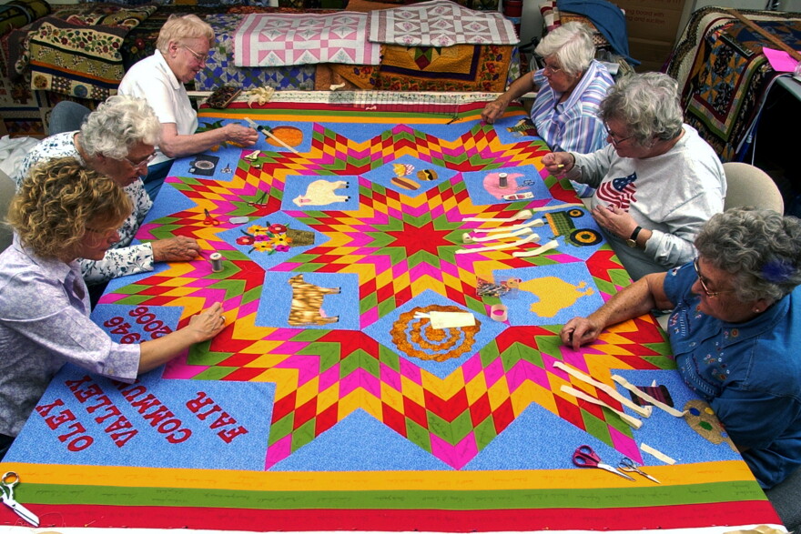 Clockwise starting in the lower left corner are: Gail D Kessler of Oley, Regina M Moyer of Shanesville, Marie R Moyer, of Shanesville, Laura K Rhoads of Oley, Eleanor A Shaner of Kutztown, and Betty D Hoch of Oley.During a Quilting Bee at the Lady Finger Studio on Oley Turnpike Road in Oley Saturday afternoon. The women at the Bee were finishing a quilt that Gail D Kessler designed and made the top for (Gail is one of the six women in the Bee, and the owner of Lady Finger).The Quilt contains pieces with signatures of people who donated money at last year's fair. The quilt will be auctioned off at this year's Oley Valley Fair, which is celebrating it's 60th anniversary.