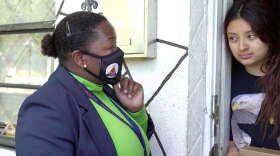Broward County Public Schools social worker Lilia Francois gives Marjory a laptop for online classes during a visit to her home on Dec. 3, 2020. Marjory's mother, María, said the family has not had a computer or consistent access to the internet during the pandemic. Florida Public Media is not using their last names to protect the family's privacy. Photo: David Diez/South Florida PBS