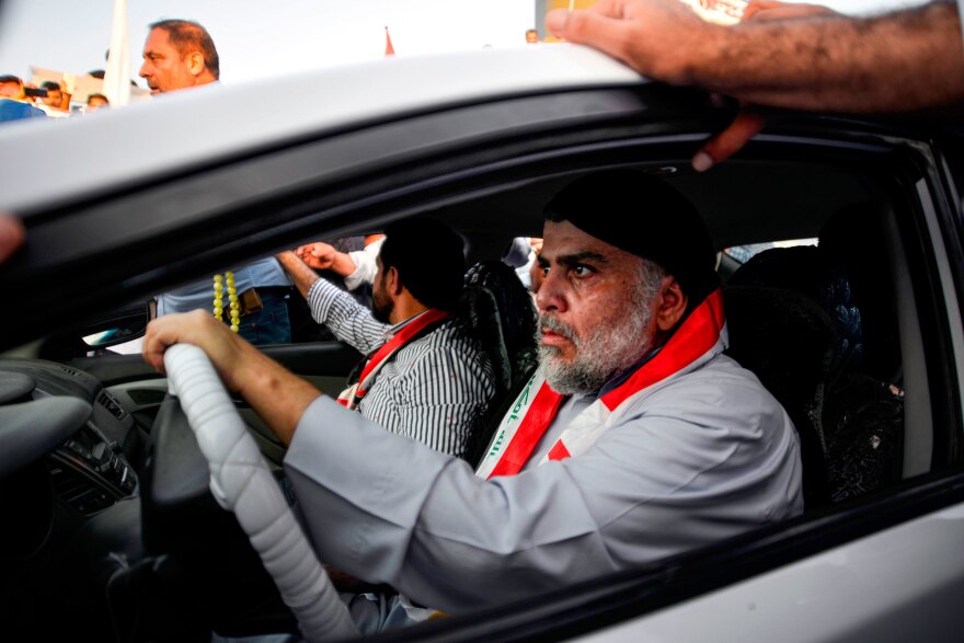 Iraqi Shiite cleric Muqtada al-Sadr drives a car as he joins anti-government demonstrators gathering in the central holy city of Najaf on Oct. 29, 2019.