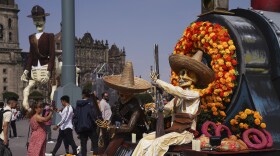 Visitors take photos of Day of the Dead themes presentations at Mexico City´s main square the Zocalo, Tuesday, Oct. 31, 2023. 