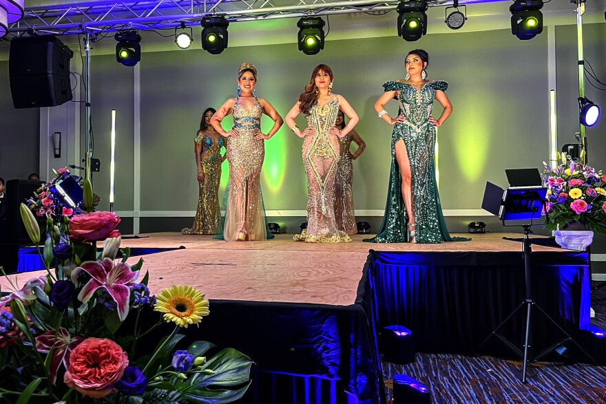 Katy Guaman (left), Emily Paredes (center), and Noelia Cabezas (right) are standing on stage as the three finalists of the pageant. This is the first pageant that the Association of Ecuadorians of Connecticut put on, and the first big event of their inaugural year as an organization. They held it on the evening of May 29, 2026 at the Waterbury Marriott Hotel.