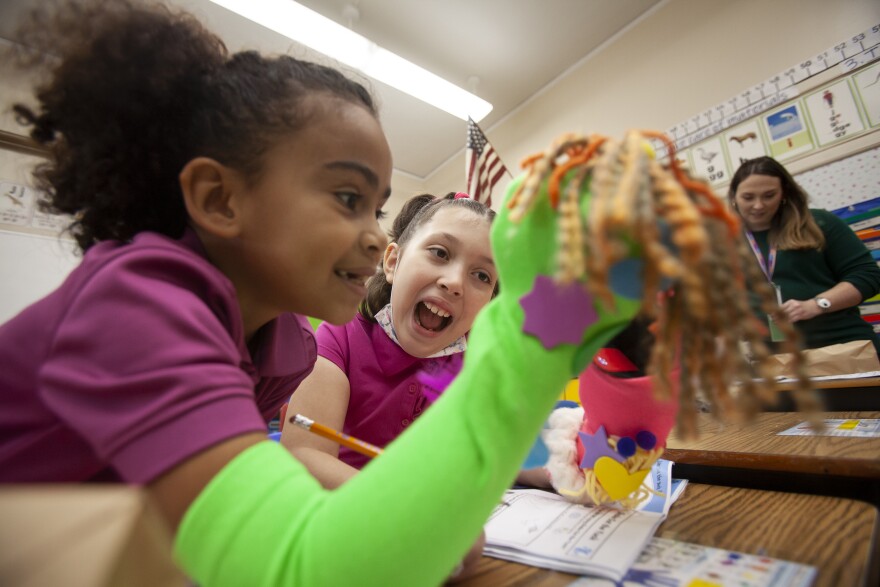 Natchaug Elementary first graders Dayshaneliz and Anaelise play with their handmade puppets.