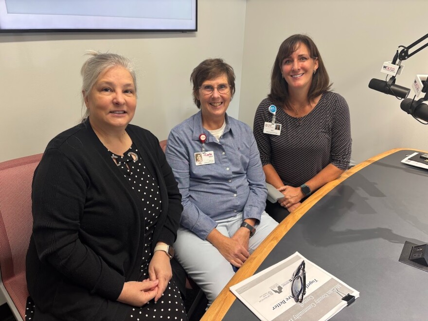 Three women pose for a photo in the WGLT studios