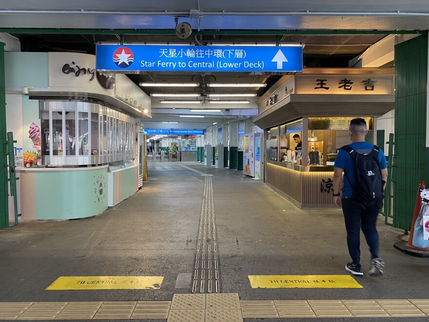 One person walks toward the entrance to board the ferry. Cross-harbor tunnels and a world-class subway system whittled down the number of commuters that relied on the ferry.