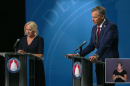 Incumbent Blake Moore and Rep. Karianne Lisonbee stand behind podiums on stage. 