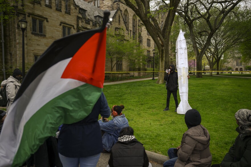 A protester holding a replica of a bomb speaks to a group of Yale students and other demonstrators supporting Palestine on April 30, 2024 after police tore down a second encampment on campus that students constructed to protest of the school’s investment in weapons manufacturers associated with Israel.