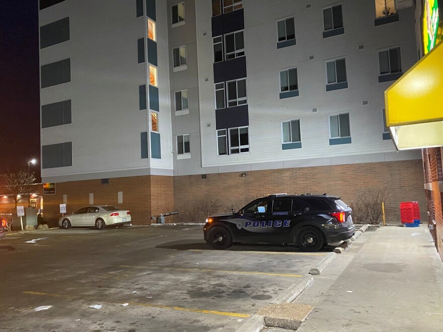 Black police SUV parked in a parking lot in front of a store and next to a large apartment building
