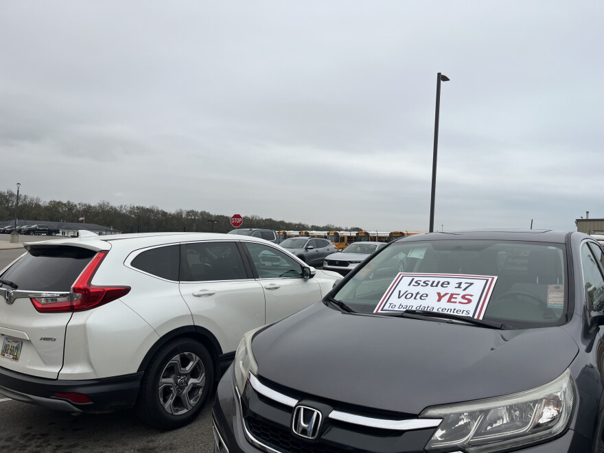 A supporter of Issue 17, which seeks to ban large-scale data centers in Trenton, displays a sign on their car outside of the AWS open house. A handful of people were handing out similar yard signs and sharing information about the ballot initiative.