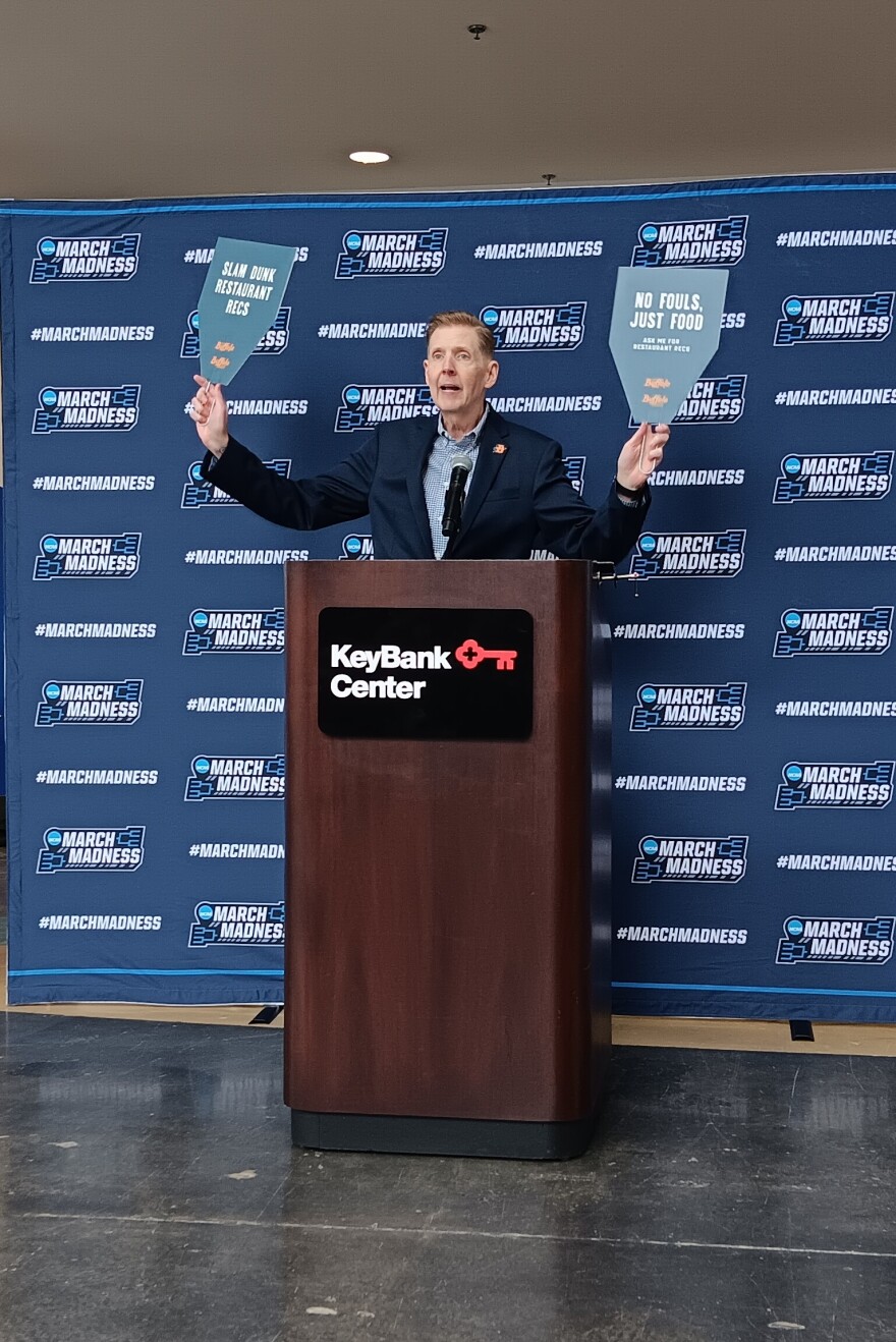 Patrick Kaler, president and CEO of Visit Buffalo Niagara, holds up some of the signs volunteers will use to attract visitors in need of information while attending this week's NCAA Men's Basketball Tournament games in Buffalo.