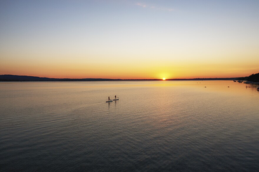 Paddle boarders cross Platte Lake, Michigan, where a decades-long campaign reduced algal blooms caused by runoff from a fish hatchery.