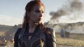 A still from the film "Black Widow," featuring Scarlett Johansson as the titular character looking out into a field.
