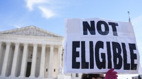 FILE - A demonstrator holds a sign outside of the U.S. Supreme Court, Feb. 8, 2024, in Washington. A pair of recent U.S. Supreme Court actions has opened the door to a new legal frontier in which local and state officials can be disqualified from office for life for engaging in "insurrection" or providing "aid and comfort" to enemies of the Constitution, based on a post-Civil War-era provision of the nation's foundational legal document and how the courts interpret it. (AP Photo/Mariam Zuhaib, File)