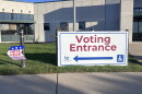 A big white sign with a red arrow and letters reads: "Voting Entrance."